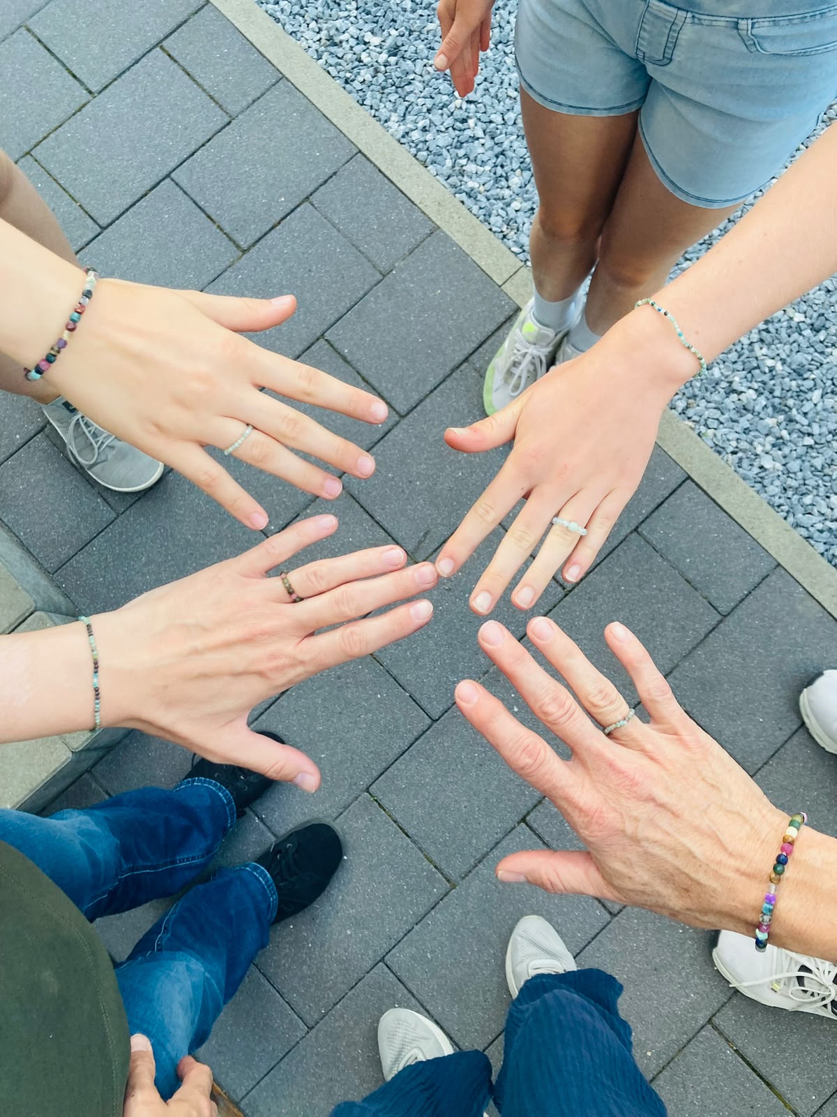 Teilnehmerinnen zeigen selbst gestaltete Ringe und Armbänder